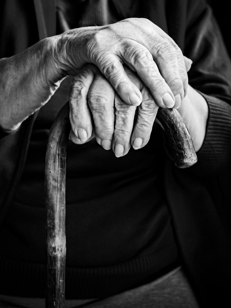an-elderly-persons-hands-rest-on-a-cane-wlzlcaf-x4u